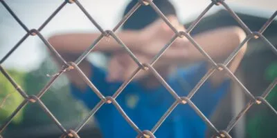 asian kid boy crying behind a metal chain wire mes 2024 12 05 16 55 13 utc SOVA PRO business featured