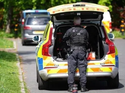 Kenton synagogue attack, image shows police officer stood behind a police car on a leafy street