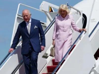 Карл III и Камилла спускаются по трапу самолета