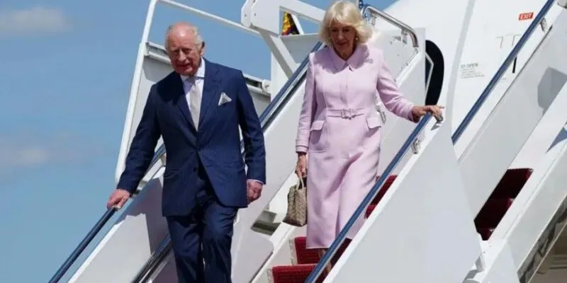 Карл III и Камилла спускаются по трапу самолета