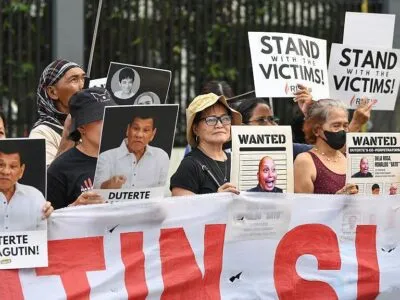 Родственники подозреваемых в наркоторговле, которые, как утверждается, были незаконно убиты по приказу бывшего президента Филиппин Родриго Дутерте, держат портреты Дутерте и его предполагаемых соучастников во время митинга на одной из улиц Манилы 11 марта 2026 года — в первую годовщину ареста бывшего президента и его передачи в Международный уголовный суд (МУС), расположенный в Нидерландах.
