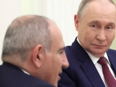 Путин смотрит на Пашиняна во время их встречи в Кремле.