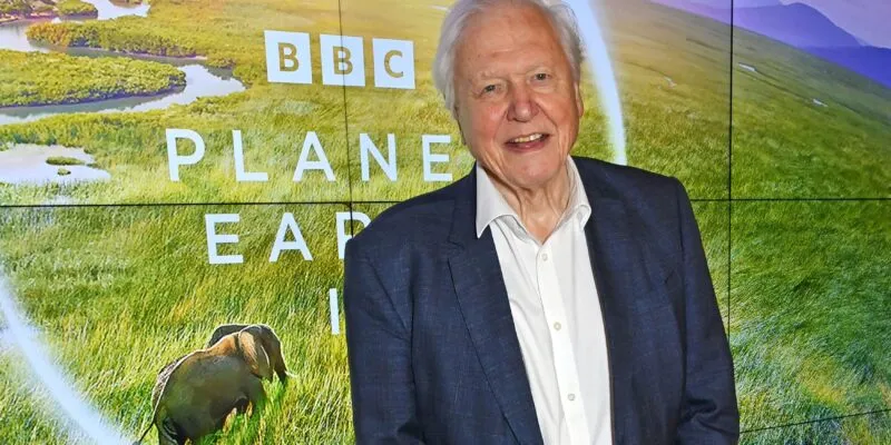 Дэвид Аттенборо на фоне плаката фильма BBC Studios «Планета Земля III»