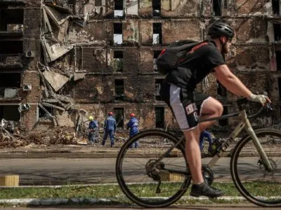 Эскалация ради эскалации? Как понимать новые угрозы России «системно бить по Киеву» 2 Велосипедист в Киеве на фоне разрушенного здания