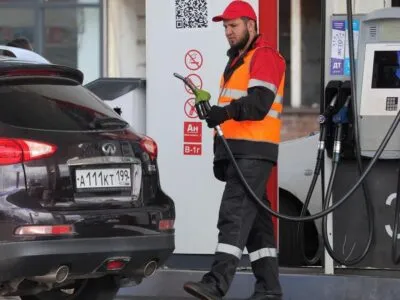Сотрудник автозаправки у автомобиля
