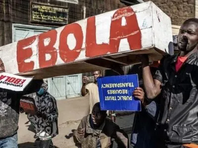 В Кении полиция снова разогнала акцию протеста против планов США построить карантинный центр для больных Эболой американцев 7 Протестующие несут белый гроб из картона, на боку которого красной краской написано слово «Эбола», и плакаты с надписями на суахили «Мы против Эболы» и на английском языке «Доверие общества требует прозрачности».