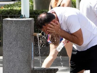 Прогноз — выше 40°C. Во многих странах Европы объявлен красный уровень опасности из-за жары 3 Мужчина умывается у питьевого фонтанчика в Испании. На нем белая футболка и черные шорты