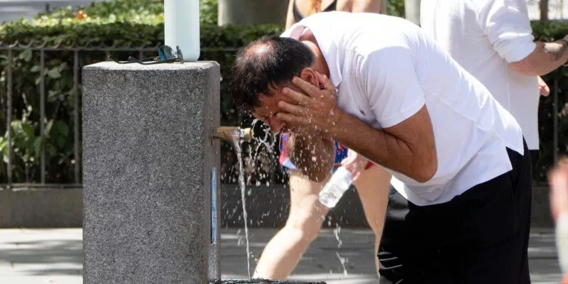 Прогноз — выше 40°C. Во многих странах Европы объявлен красный уровень опасности из-за жары 1 Мужчина умывается у питьевого фонтанчика в Испании. На нем белая футболка и черные шорты