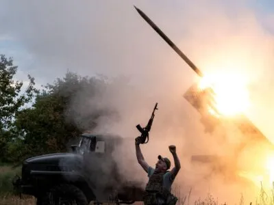 Наступил ли перелом в войне России с Украиной? 4 Военный вздымает в воздух автомат на фоне установки "Град", стреляющей ракетой