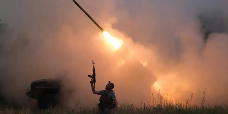 A Ukrainian soldier from the 93rd Kholodnyi Yar Separate Mechanized Brigade of the Ukrainian Armed Forces reacts as his colleagues fire a BM-21 Grad multiple launch rocket system towards Russian troops