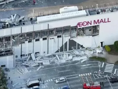 Вид с высоты птичьего полета на торговый центр Aeon Mall с разбитыми окнами и обломками на парковке