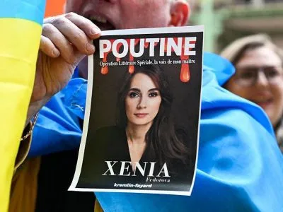 Франция высылает бывшую главу филиала RT Ксению Федорову 3 Сторонники Украины устроили акцию протеста на презентации книги Ксении Федоровой в прошлом апреле в Париже - участник акции держит фото Федоровой с надписями "Путин" и "Ксения"