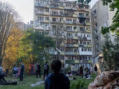 Ребенок сидит во дворе дома, по которому пришелся удар.