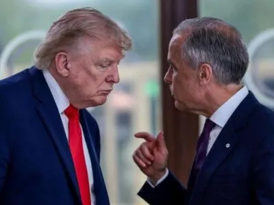 A file image showing U.S. President Donald Trump at a working lunch with Prime Minister Mark Carney and other G7 leaders. The image shows Carney and Trump side by side mid-conversation. Both are wearing a suit. Carney is gesturing with his hand mid-speech, while Trump hangs his head low to listen.