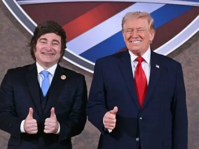 Хавьер Милей и Дональд Трамп в темных костюмах поднимают большой палец вверх в качестве знака одобрения