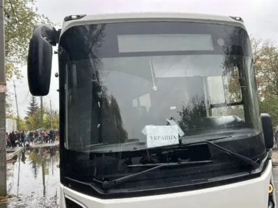 Автобус с надписью УКРАИНА, рядом стоят люди.