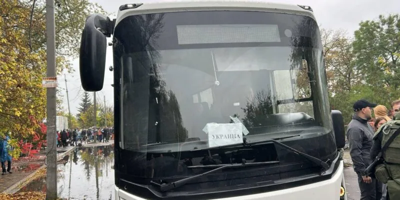 В Алешках началась эвакуация мирных жителей 1 Автобус с надписью УКРАИНА, рядом стоят люди.